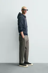 Pantalón de corte carrot fit confeccionado en tejido de algodón con estructura diagonal y efecto lavado. Presenta bolsillos frontales con bolsillo cerillero, bolsillos traseros de plastrón y cierre frontal con cremallera y botón.