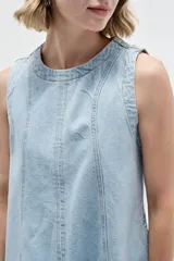 Vestido corto de jean blanco con tirantes anchos, cuello redondo, corte holgado y bolsillos laterales.