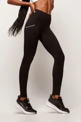 Calza deportiva de tiro alto confeccionada en poliamida de alta performance. Presenta bolsillos laterales con costuras en color contrastante y detalle de logo estampado en la pierna.