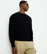 Suéter masculino de punto piqué con textura, cuello redondo y mangas largas. Presenta un diseño básico y versátil, confeccionado en algodón sostenible.