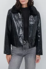 Chaqueta de efecto cuero brillante con acabado charol, cuello con solapas de piel sintética, cierre frontal con botones y bolsillos laterales.