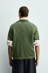 Polo regular fit verde de punto de algodón, con cuello solapa, abertura frontal y diseño de calados geométricos en rombos.