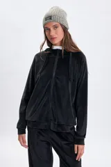 Campera de plush color negro con cierre frontal, capucha con cordones ajustables y mangas ranglan. Presenta un diseño cómodo y versátil con puños y ruedo acanalados.