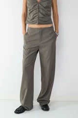 Pantalón de corte recto y tiro medio, confeccionado en tejido crepé con diseño de raya diplomática. Presenta una caída fluida, bolsillos laterales y cierre frontal.