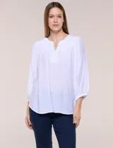 Blusa blanca de rayón y poliéster con textura, escote en V y delicados bordados al tono sobre el canesú. Cuenta con mangas raglán tres cuartos abullonadas con puños elastizados y diseño holgado.