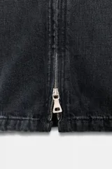 Pantalón de jean negro de tiro medio, corte wide leg y largo hasta el tobillo. Tiene bolsillos delanteros y traseros, trabillas en la cintura, efecto lavado y cremalleras metálicas en el ruedo.