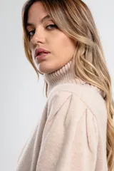 Polera de tejido de punto color negro, con cuello tortuga alto y puños y ruedo acanalados.