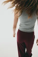 Pantalón sastrero de tiro alto, color bordó, con piernas rectas y pliegues marcados en el frente.