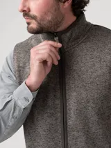 Chaleco de hombre con cierre frontal completo, confeccionado en tejido polar jaspeado con interior de micropolar. Cuenta con cuello alto y dos bolsillos laterales con cierre.