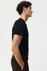 Remera H&M de corte ajustado en punto suave de algodón pima, con cuello redondo ribeteado acanalado fino y mangas cortas.