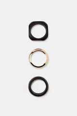 Pack de tres pulseras rígidas para mujer, compuesto por una pulsera metálica lisa dorada, una pulsera de madera lisa con diseño cuadrado y una pulsera de madera labrada con patrones geométricos en tono marrón oscuro.