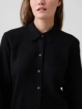 Camisa de lino negra de manga larga, con cuello camisero clásico y cierre frontal de botones.