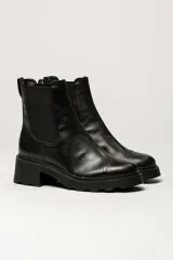 Bota tipo Chelsea de cuero color verde oliva, con paneles laterales elásticos negros y suela track de goma negra con taco cuadrado.