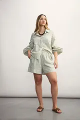 Short a rayas verticales color verde y blanco, con cintura elástica ajustable con cordón.