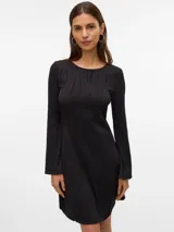 Vestido midi de color negro con textura acanalada ondulada, cuello redondo y mangas largas. Presenta un diseño ajustado al cuerpo con una caída fluida.