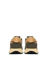 Championes Autry modelo Reelwind Low, confeccionados en una combinación de gamuza y malla en tono verde oliva. Presentan detalles en cuero color tostado en el lateral y el talón, con suela de goma en color crema y logo de la marca con bandera estadounidense en el lateral.