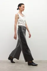 Jean wide leg bicolor en tonos de gris oscuro, con paneles laterales más oscuros y ruedo deshilachado.