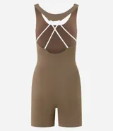 Enterito deportivo corto color marrón topo, ajustado al cuerpo, con escote en V pronunciado y breteles finos blancos que se cruzan en la espalda.