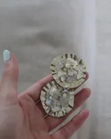 Aros circulares con base de alpaca y apliques de nácar, perlas y piedras. Cierre a presión.