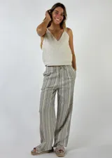 Pantalón largo de lino a rayas verticales en tonos beige, rosa y gris, con cintura alta y corte recto.