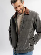 Campera liviana de color gris oscuro con cuello de pana en color marrón. Presenta cierre frontal completo, un bolsillo en el pecho y bolsillos laterales.