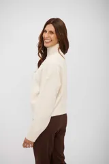 Sweater de punto con cuello alto, manga larga y corte holgado.