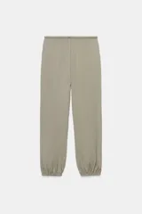 Pantalón bombacho de tiro medio color vino, con cintura ajustable mediante cordón y puños elásticos ajustables con botón en los tobillos.