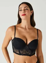 Soutien tipo corset negro, con copas con aros y tirantes finos ajustables. El cuerpo es de encaje con paneles de transparencia y un bajo con borde festoneado.