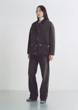 Jeans de tiro alto y diseño recto en color negro lavado. Cuenta con cinco bolsillos, trabillas para cinturón y cierre frontal con cremallera y botón metálico.