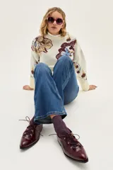 Zapato acordonado de cuero color bordó, con punta fina y detalle de ojalillos metálicos dorados en el empeine.