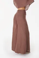 Pantalón de lino italiano con diseño estampado a rayas verticales en tonos negro y beige, de tiro medio y corte ancho.