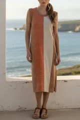 Vestido midi sin mangas, con rayas verticales en tonos naranja, beige y marrón. Confeccionado en tejido de punto suave al tacto.