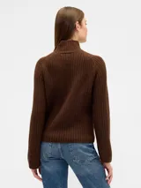 Buzo de punto acanalado color marrón, con cuello alto y mangas largas con puños acampanados.