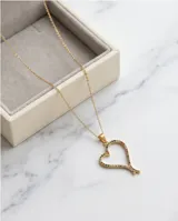 Collar de acero con baño de oro, compuesto por una cadena fina y un dije en forma de corazón calado decorado con pequeñas circonias multicolor.