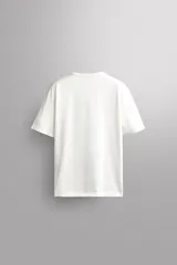 Camiseta de algodón gris melange con cuello redondo, mangas cortas y efecto lavado. Presenta un estampado de texto frontal en color oscuro con efecto desgastado.
