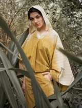 Poncho con capucha a rayas horizontales verdes y blancas, con falda a rayas verticales rosas y marrones.