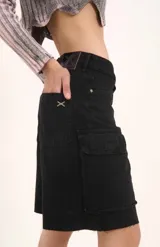 Bermuda de tiro medio confeccionada en denim negro, con calce relajado y estilo cargo. Presenta bolsillos laterales con solapa y terminación desflecada en el ruedo.