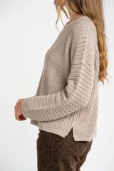 Sweater de punto texturado en color bordó con destellos de lurex, de corte holgado, cuello redondo y mangas largas.