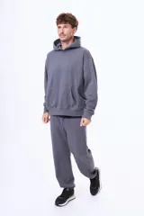 Buzo tipo canguro de felpa color gris, con capucha amplia, bolsillo frontal tipo canguro y puños acanalados.