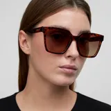 Lentes de sol con montura cuadrada de estilo oversized en estampado carey y cristales polarizados en color marrón.