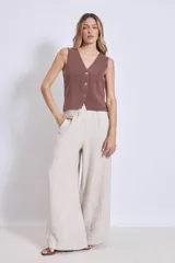 Chaleco de punto color crema con escote en V y cierre frontal con botones a tono.