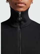 Vestido corto negro de algodón con cuello alto, cierre frontal con cremallera, mangas cortas, dos bolsillos con solapa en la falda y falda acampanada.