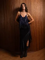 Pollera midi de terciopelo negro con corte asimétrico y detalle de encaje en el ruedo.