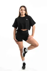Conjunto deportivo negro compuesto por remera crop top de algodón con logo bordado y short de calce ajustado con cintura cruzada.