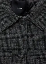 Chaqueta corta de tweed a cuadros grises, con cuello camisero, solapas decorativas, cierre frontal con botones y bajo con goma elástica.
