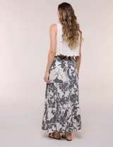 Falda maxi color crudo con estampado floral en tonos oscuros, tiro alto con cintura elástica fruncida, cordón de ajuste frontal y diseño escalonado de tres paneles con vuelo.