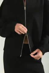Campera deportiva de cuello alto con cierre frontal completo, mangas largas con puños elásticos y diseño holgado.