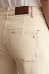 Jean de corte culotte y tiro medio, color beige, con diseño de perneras anchas y terminación desmechada en el bajo.