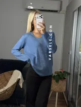 Sweater de punto color bordó con escote en V y detalle de strass aplicado en la parte frontal. Presenta mangas largas y corte holgado.