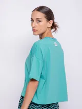 Remera negra de corte crop con mangas cortas y cuello redondo con ribete de flores. Estampado de flores rosas en el pecho.